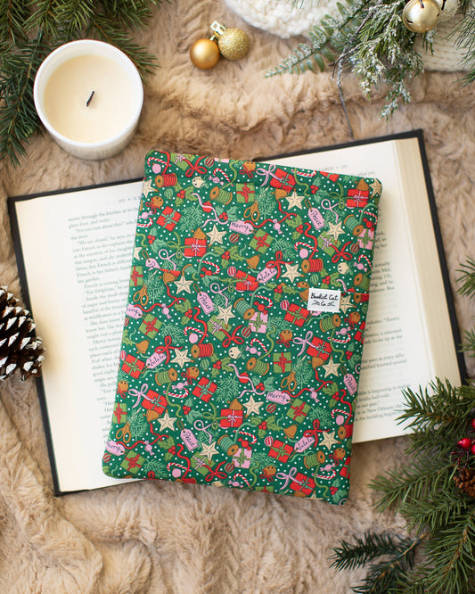 Holiday book sleeve with gifts, bows, gift tags, stars, candy canes and sprigs of holly. 