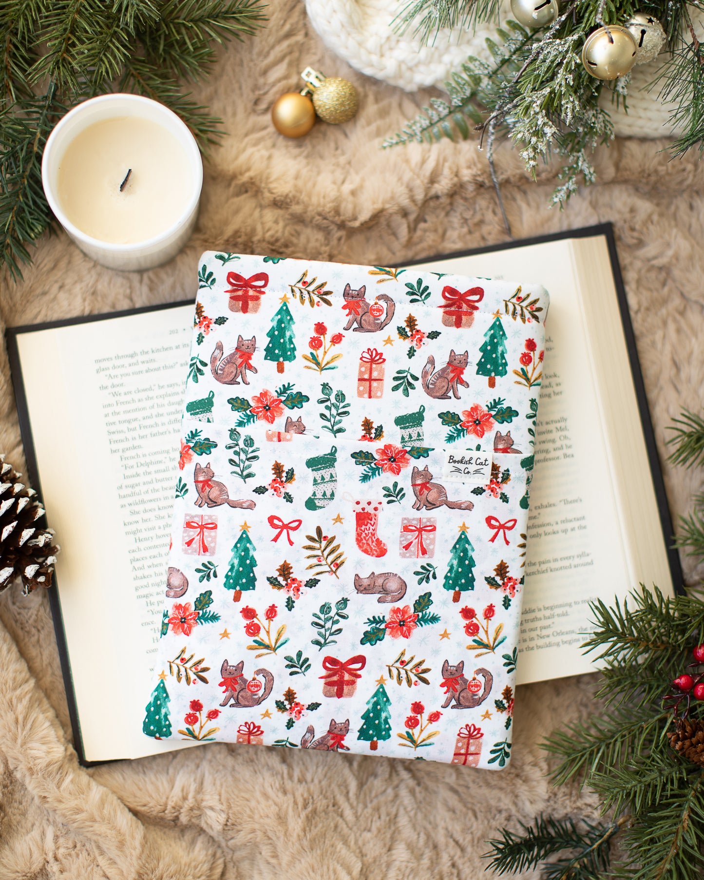 Book sleeve with Christmas cats wearing red bows with trees and stockings.